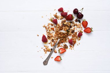 Beyaz ahşap arka planda fındıklı, hindistan cevizli ve dutlu granola. Yukarıdan görüntüle.