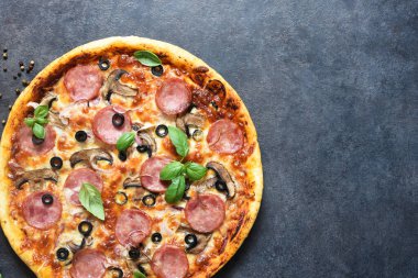 Siyah arka planda salamlı, mantarlı ve domates soslu pizza. Yukarıdan görüntüle.