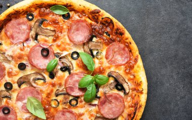 Siyah arka planda salamlı, mantarlı ve domates soslu pizza. Yukarıdan görüntüle.