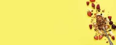 Sarı arka planda fındık ve böğürtlenli granola. Yukarıdan görüntüle.