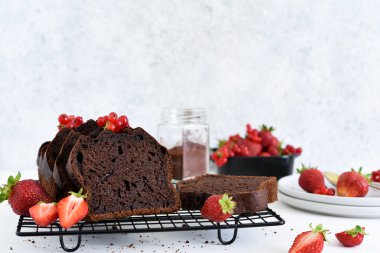 Çilekli çikolatalı kek ve hafif beton arka planda frenk üzümü. Çocuk oyuncağı. Brownie turtası.