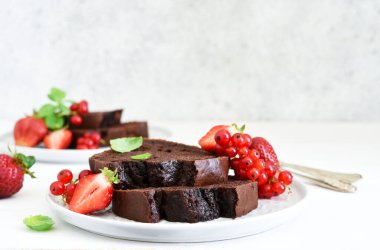 Çilekli çikolatalı kek ve hafif beton arka planda frenk üzümü. Çocuk oyuncağı. Brownie turtası.