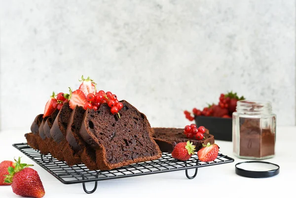 Çilekli çikolatalı kek ve hafif beton arka planda frenk üzümü. Çocuk oyuncağı. Brownie turtası.