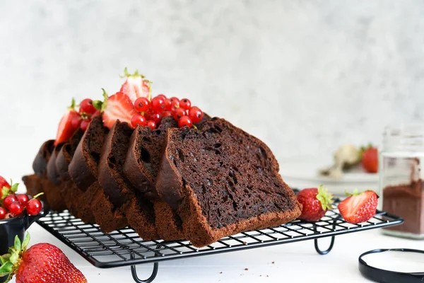 Çilekli çikolatalı kek ve hafif beton arka planda frenk üzümü. Çocuk oyuncağı. Brownie turtası.