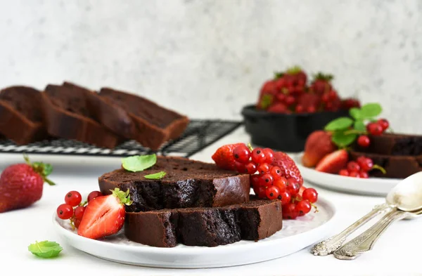Çilekli çikolatalı kek ve hafif beton arka planda frenk üzümü. Çocuk oyuncağı. Brownie turtası.