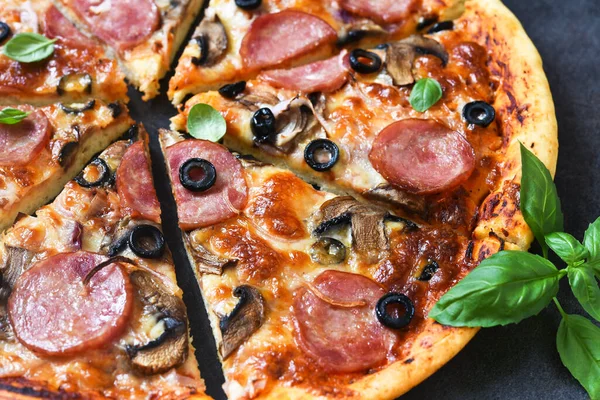 Siyah arka planda mantarlı ve zeytinli pizza dilimleri..