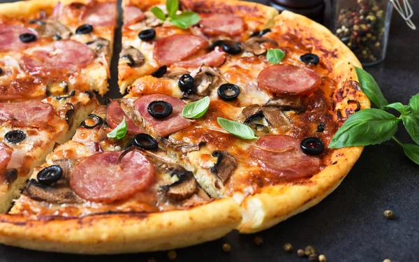 Siyah arka planda mantarlı ve zeytinli pizza dilimleri..