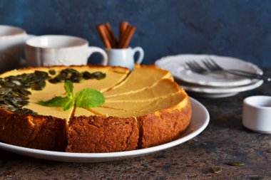 Mavi beton arka planda ev yapımı klasik balkabaklı cheesecake. Yatay odak.