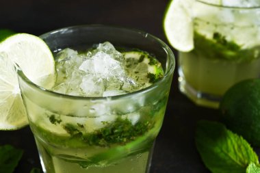 Yaz kokteyli. Klasik yaz içkisi. Karanlık bir arka planda bardakta mojito..