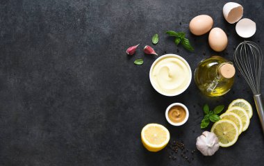 Siyah arka planda ev yapımı mayonez. Sos yapmak için gerekli malzemeler: yumurta, tereyağı, hardal.