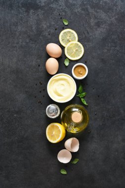 Siyah arka planda ev yapımı mayonez. Sos yapmak için gerekli malzemeler: yumurta, tereyağı, hardal.