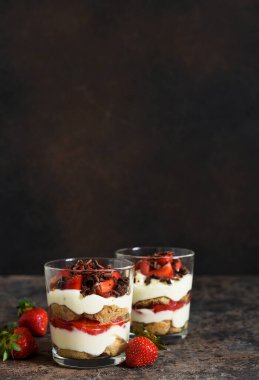 Krem peynirli tatlı, çilek ve beton arka planda bir bardakta çikolata. Çilekli tiramisu..