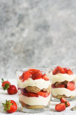 Çilekli tiramisu, beton arka planda bir bardakta. Klasik İtalyan tatlısı..