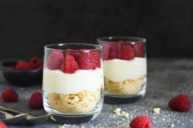 Beton arka planda bir bardakta ahudududulu cheesecake. Klasik tatlı..