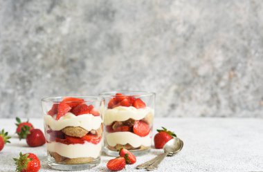 Çilekli tiramisu, beton arka planda bir bardakta. Klasik İtalyan tatlısı..