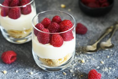 Beton arka planda bir bardakta ahudududulu cheesecake. Klasik tatlı..