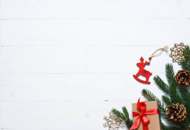 Noel kartı. Beyaz ahşap arka planda kutuları ve köknarı olan bir Noel düzeni.