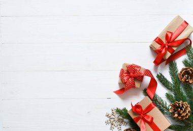 Noel kartı. Beyaz ahşap arka planda kutuları ve köknarı olan bir Noel düzeni.