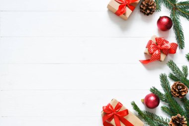 Noel kartı. Beyaz ahşap arka planda kutuları ve köknarı olan bir Noel düzeni.