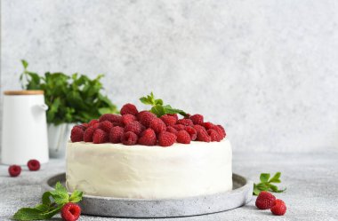 Mutfak arka planında krema ve ahududu olan doğum günü pastası..