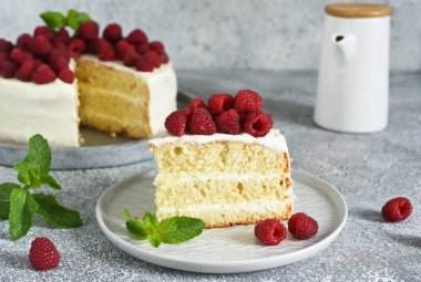 Bir dilim kek. Krem peynirli ve ahududulu doğum günü pastası ve beton mutfak arka planında nane şekeri.