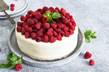 Mutfak arka planında krema ve ahududu olan doğum günü pastası..