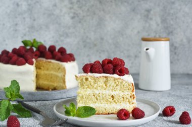Bir dilim kek. Krem peynirli ve ahududulu doğum günü pastası ve beton mutfak arka planında nane şekeri.