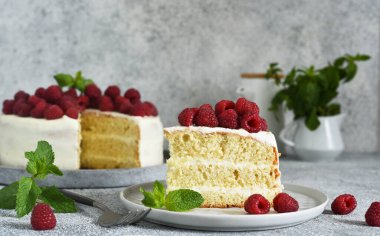 Bir dilim kek. Krem peynirli ve ahududulu doğum günü pastası ve beton mutfak arka planında nane şekeri.