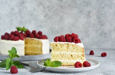 Bir dilim kek. Krem peynirli ve ahududulu doğum günü pastası ve beton mutfak arka planında nane şekeri.