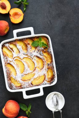 Şeftalili, şeftali arkaplanına pudra şekeri serpiştirilmiş lezzetli bir pasta.