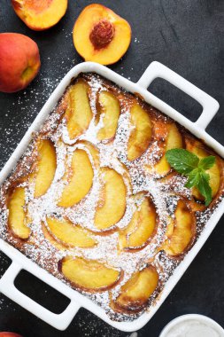 Şeftalili, şeftali arkaplanına pudra şekeri serpiştirilmiş lezzetli bir pasta.