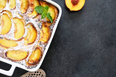 Şeftalili, şeftali arkaplanına pudra şekeri serpiştirilmiş lezzetli bir pasta.