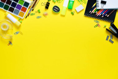 Okula dönelim. Sarı arka planda okul malzemeleri. Okul aksesuarlarının düzeni.