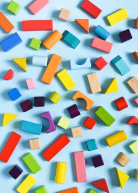 Açık mavi arka planda ahşap renkli küpler. Yukarıdan bak. İnşaat.