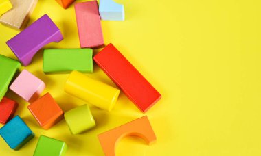 Sarı arka planda ahşap renkli küpler. İnşaat.