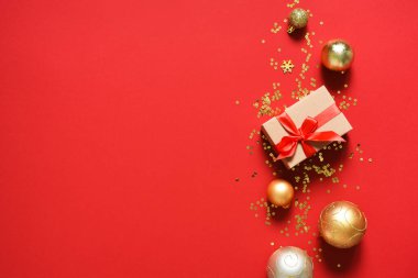 Kırmızı arka planda hediyeler ve toplarla güzel bir Noel süsü. Yukarıdan bak. Yeni Yıl Planı.