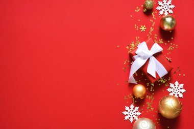 Kırmızı arka planda hediyeler ve toplarla güzel bir Noel süsü. Yukarıdan bak. Yeni Yıl Planı.