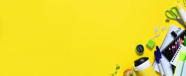 Okula dönelim. Okul malzemeleri ve sarı arka planda bir elma. Okul aksesuarlarının düzeni. Uzaktan öğrenme..