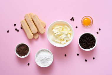 Pembe arka planda tiramisu hazırlamak için gerekli malzemeler. Yemek pişirme süreci. Klasik İtalyan tatlısı..