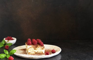 Koyu beton arka planda ahududulu tiramisu. Klasik İtalyan tatlısı tiramisu..