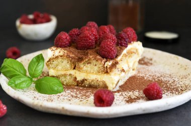 Koyu beton arka planda ahududulu tiramisu. Klasik İtalyan tatlısı tiramisu..