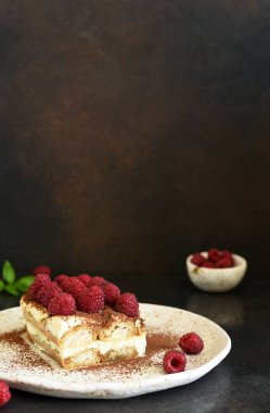 Koyu beton arka planda ahududulu tiramisu. Klasik İtalyan tatlısı tiramisu..