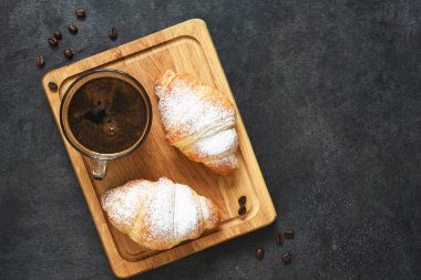 Tahtada kruvasan ve kahve macunu. Yukarıdan görüntüle.