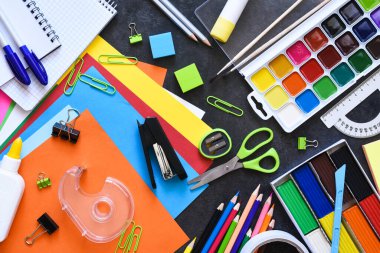 Okul malzemeleri siyah arka planda. Okul konseptine geri dönelim. Okul kırtasiyesiyle düz kompozisyon..