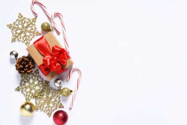 Kırmızı kurdeleli hediye kutuları ve Noel toplarıyla beyaz arka planda güzel bir Noel kompozisyonu. Yukarıdan görüntüle.