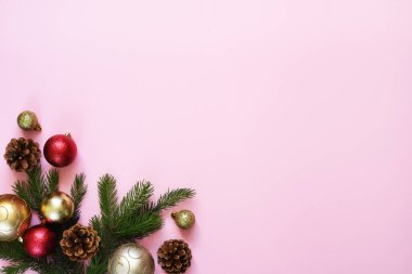 Kırmızı arka planda köknar ile güzel bir Noel kompozisyonu. Pembe arka plan, köknar, noel baloları ve dekor. Kopyalamak için boşluk olan üst görünüm.