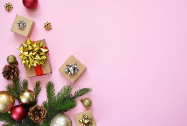 Güzel kompozisyon. Noel arkaplanı köknar, Noel hediyeleri ve dekorla birlikte pembe. Kopyalamak için boşluk olan üst görünüm.