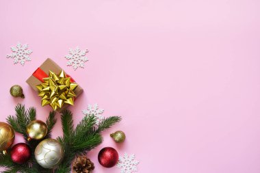 Güzel kompozisyon. Noel arkaplanı köknar, Noel hediyeleri ve dekorla birlikte pembe. Kopyalamak için boşluk olan üst görünüm.