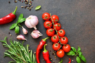 Baharatlar, acı biberler ve koyu beton arka planda domatesler. Yukarıdan görüntüle.