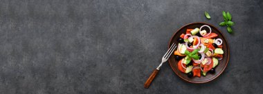 Siyah beton arka planda beyaz peynirli ve zeytinli Yunan salatası. Yukarıdan görüntüle.